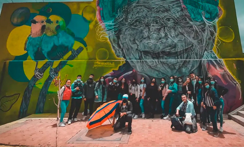 foto de un grupo de personas al lado de un grafiti