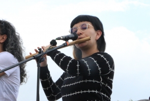 Mujer artistas toca flauta.