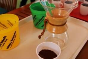 Molino, colador y taza de café sobre mesa