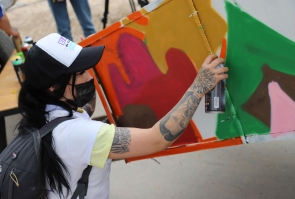 mujer artista realiza grafiti sobre carreta de reciclaje