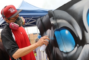 artista realiza grafiti sobre carreta