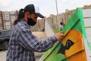 mujer artista realiza grafiti sobre carreta