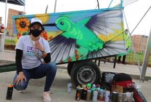 artista presenta su grafiti, colibrí gigante