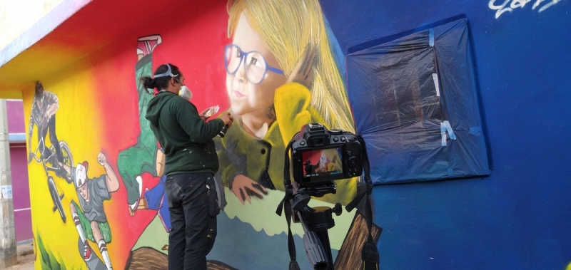 Mujer pintando mural