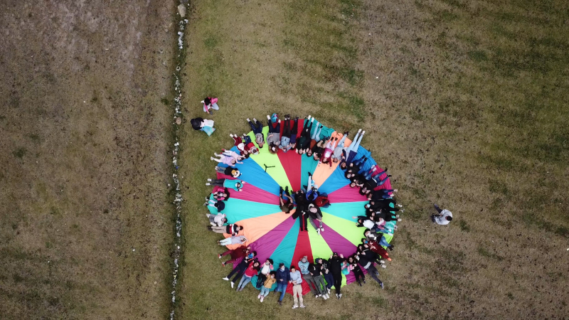 Red creadora de Bogotá - Grupo de personas acostados en círculo sobre una tela de colores