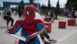 Niño disfrazado del hombre araña leyendo un libro