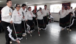 Grupo de Personas conformado por 4 hombres y 4 mujeres con Discapacidad visual realizando un baile