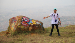 Grafiti tour en Ciudad Bolívar - Hombre con piedra pintada y vista de Bogotá